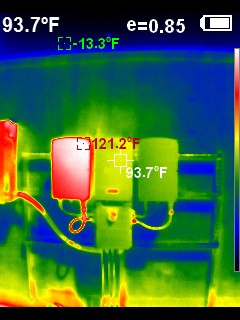 Infrared thermal image showing an enclosure reading 121.2°F, notably hotter than an adjacent 93.7°F component
