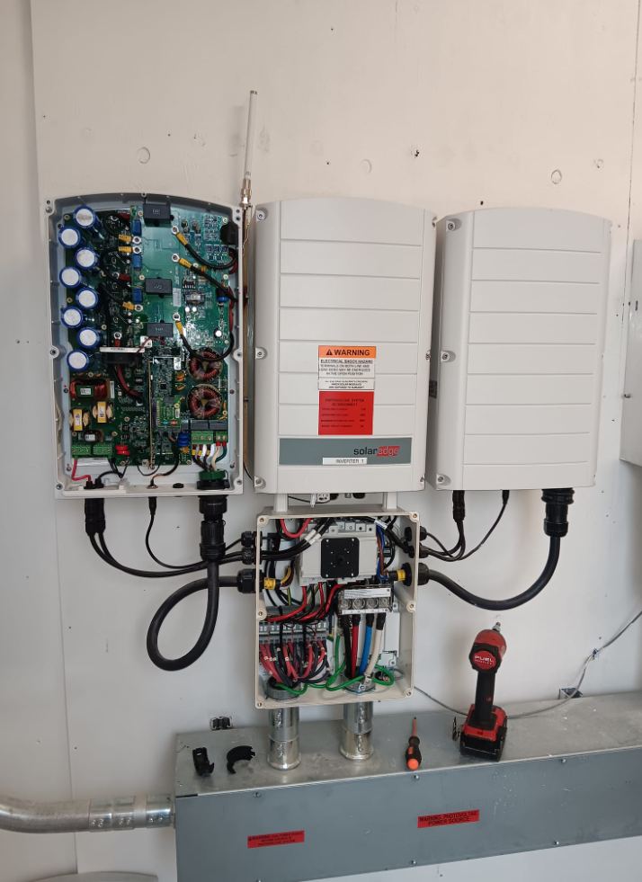 Open SolarEdge inverter enclosure showing internal circuit board next to a second closed unit